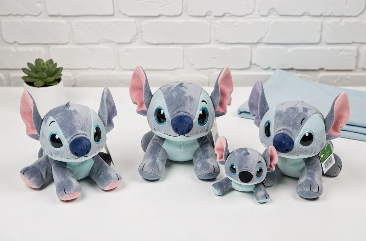 Comparatif de plusieurs peluches Stitch respirantes de différentes tailles sur une table blanche